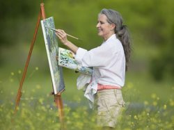 Staffelei Eine Frau malt ein Bild in der freien Natur.
