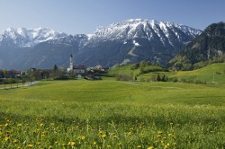 Breitenberg im Frühling Blick auf das Pfrontener Tal im Fr�hling. Inmitten blumiger Wiesen thront die Pfarrkirche St. Nikolaus und der noch schneebedeckte Breitenberg.