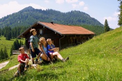 Familie an der Bärenmoosalpe Familie macht Rast nach der Wandertour zur Bärenmoosalpe über das Himmelreich und genießt die Berglandschaft.