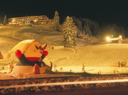 Familienskigebiet Fischen Flutlichtfahren an den beleuchteten Familienliften in Fischen mit Skimaskottchen Zimi, der Freund aller Skischulkinder.