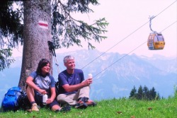 Wanderer bei der Rast Im Hintergrund die moderne 6er Kabinenbahn in Bolserlang, 3 km von Fischen entfernt