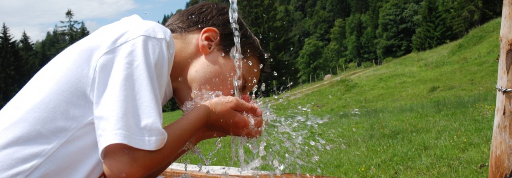 Kind bei Brunnen Header